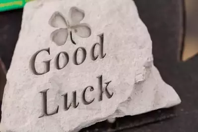A stone engraved with the phrase good luck and four-leaf clover.