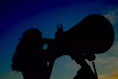 A woman using a telescope for stargazing.