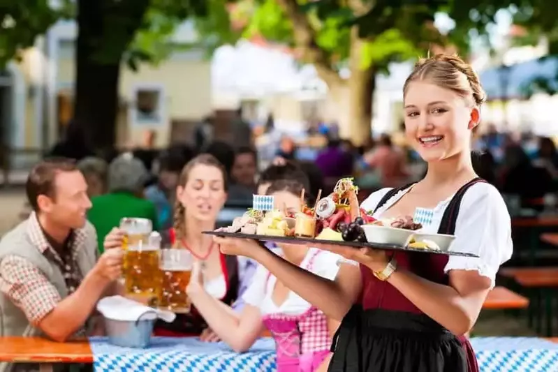 A waitress in traditional Bavarian clothing at an Oktoberfest celebration.