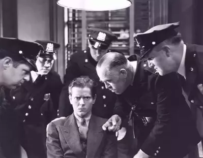 A man being interrogated by the police in the 1930s.