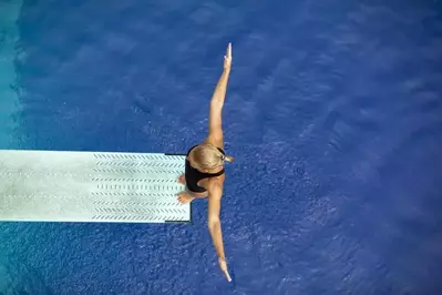 A female high diver on a diving board.