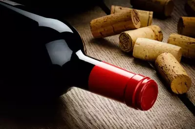 Wine bottle next to corks on a table