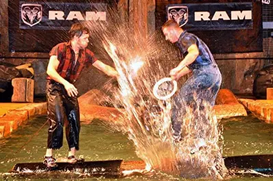 Lumberjacks on logs in water at the Lumberjack Feud