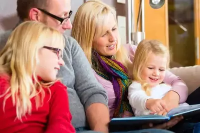 Family sitting together to read one of the books from Dolly Parton's Imagination Library