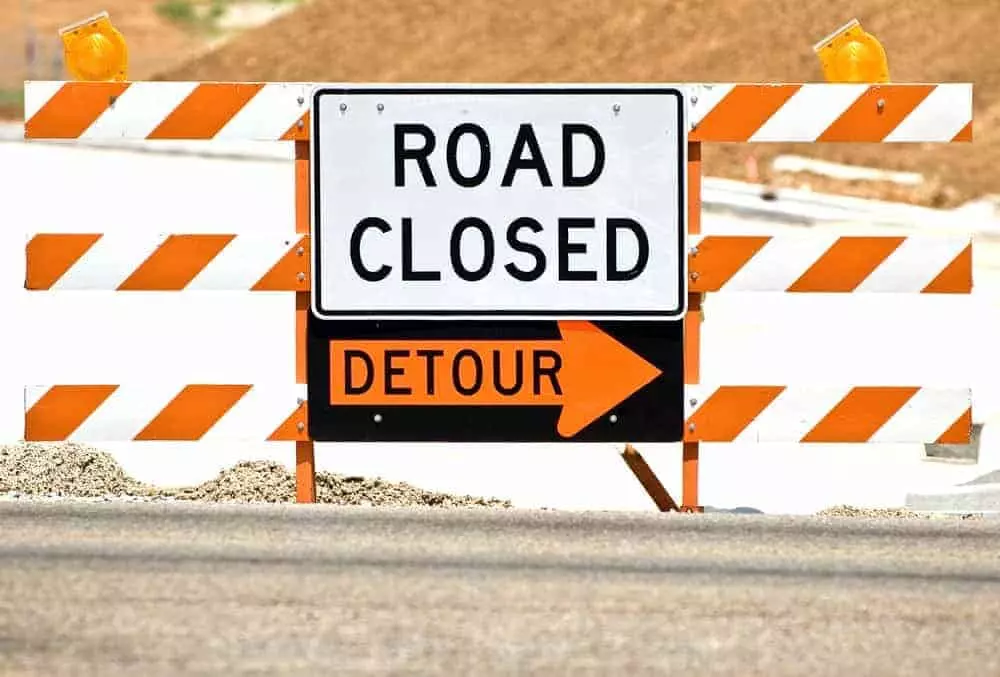 Road closed and detour sign at a construction site