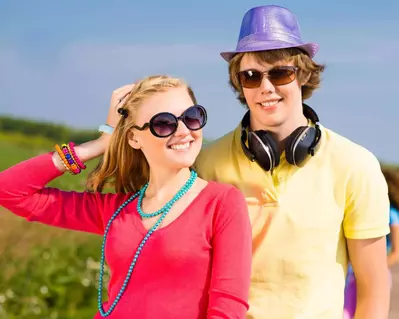 Teenager boy and girl wearing bright colored clothes having fun