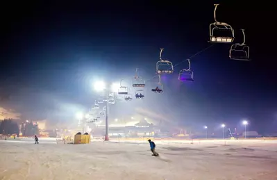 Ski resort at night with man snowboarding