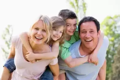 family laughing and playing outdoors