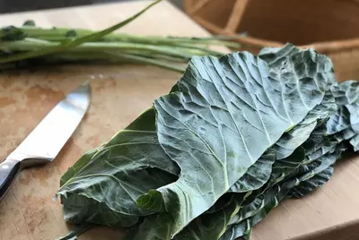 fresh collard greens on cutting board