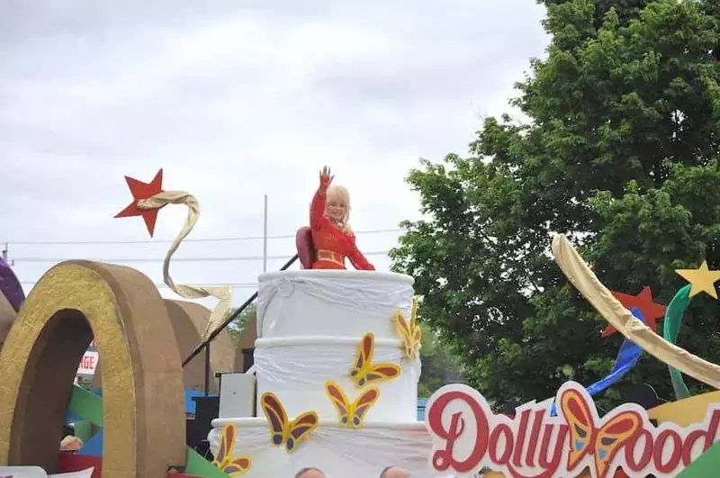 Dolly Parton waving from a float in her parade in Pigeon Forge.