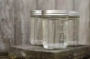 Three clear moonshine jars