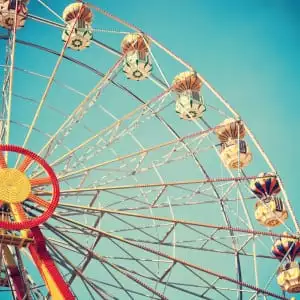 Vintage style photo of ferris wheel in blue sky