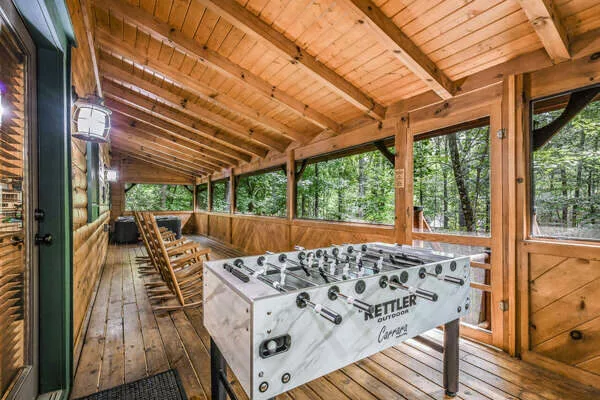 Enclosed back porch with foosball table and hot tub