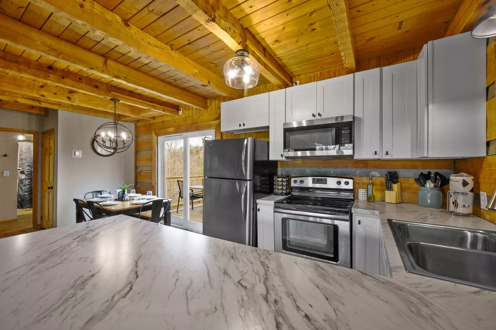 View of kitchen/dining areas and rear deck from breakfast bar.