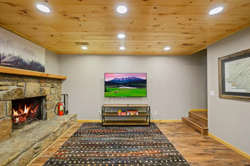 Lower level entertainment room with 65 inch Roku TV and wood burning fireplace!