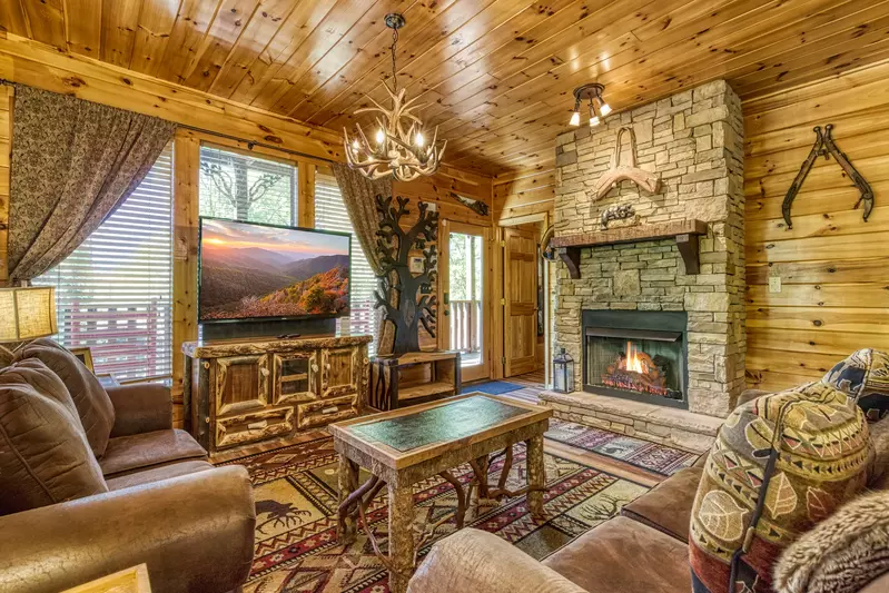 Antler Run living room with seasonal stone encased gas fireplace