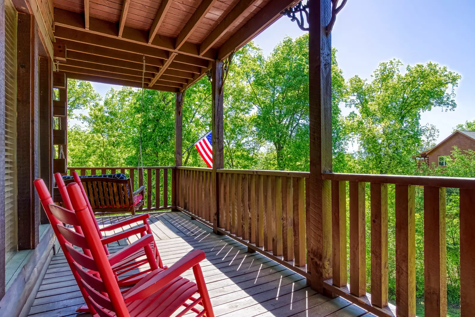 Antler Run third floor wrap around covered deck with rocking chairs