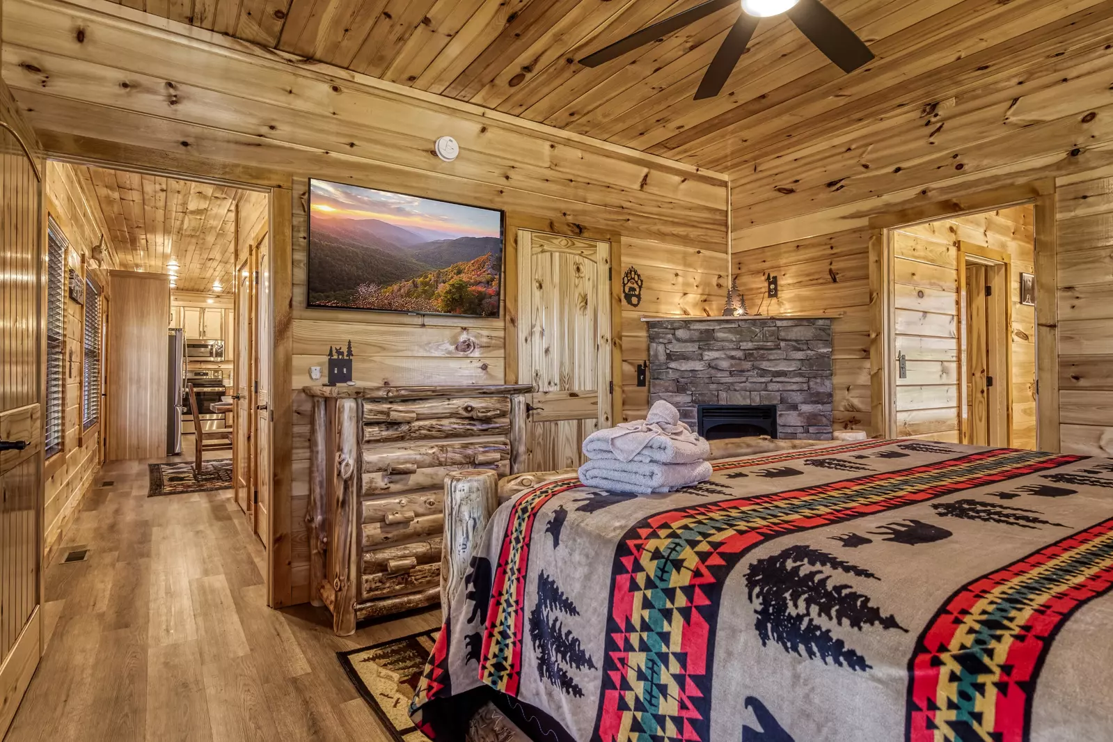 Cozy Cub Cabin main level bedroom with stone encased gas fireplace