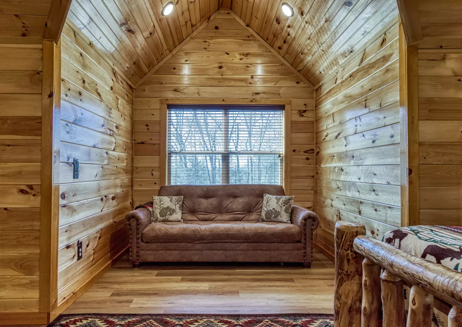 Cozy Cub Cabin upper level loft area with sofa
