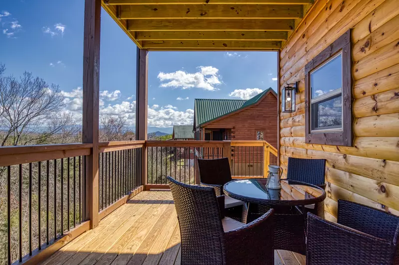 Cozy Cub Cabin main level back deck with table and chairs