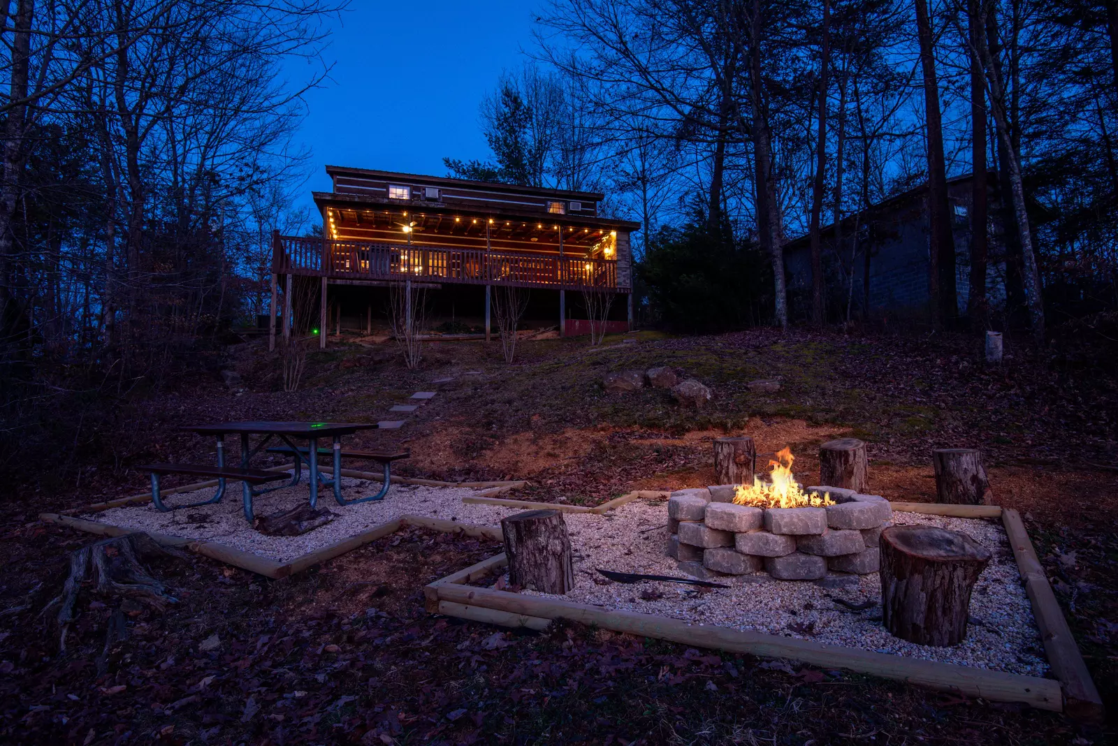 Mountain Magic outdoor fire pit and cabin at night