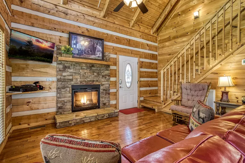 Outskirts of Heaven - Living room with seasonal stone encased gas fireplace