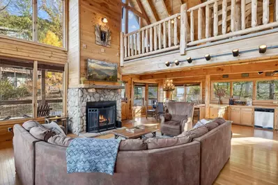 Vaulted ceilings in the living room open to the loft above and bring in two stories of light and views