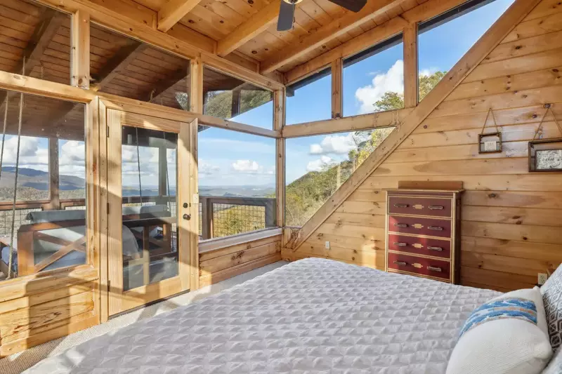 The 3rd-floor bedroom is a secluded "tree-top suite" that offers incredible views from its three walls of windows
