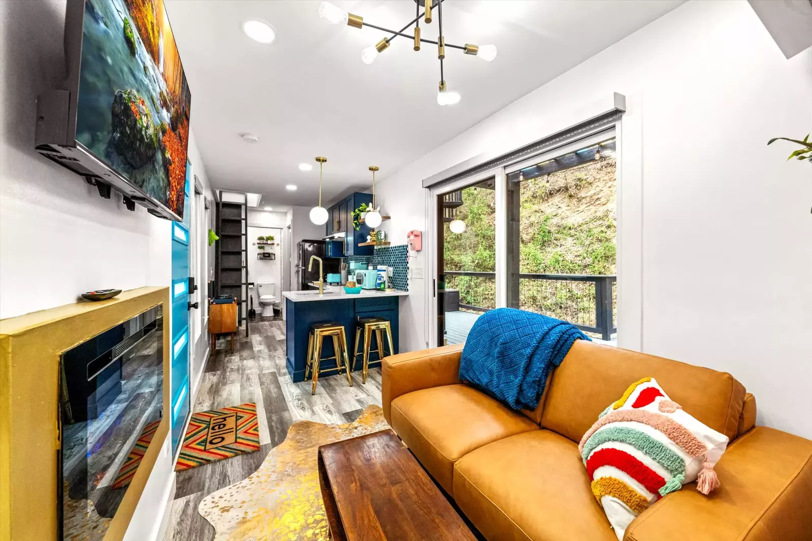 modern living room with leather sofa, gold fireplace and kitchenette