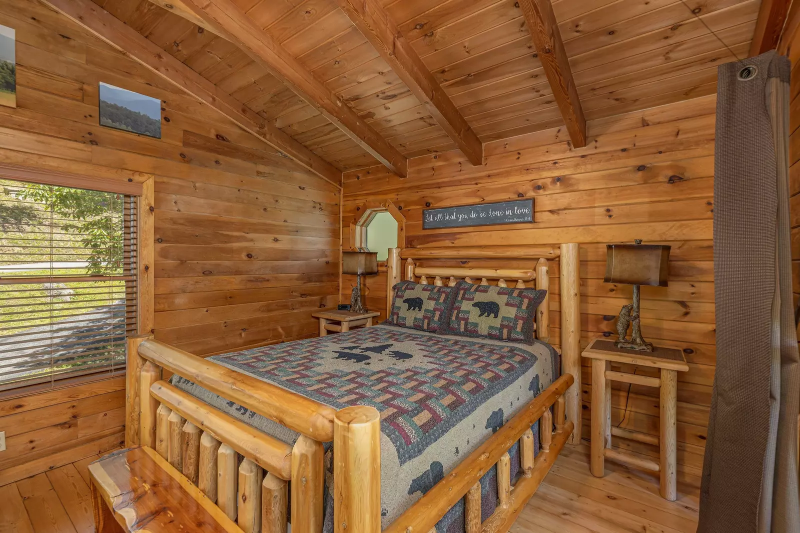 Queen log bed in the loft with privacy curtains and mountain views.