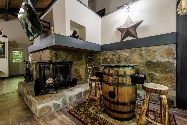 Misty Mountain Hop – a 2-bedroom, 2-bath Smoky Mountain cabin in Cobbly Nob Resort with screened-in hot tub, wrap-around decks, wood-burning fireplace, and access to pools, pickleball, and golf.