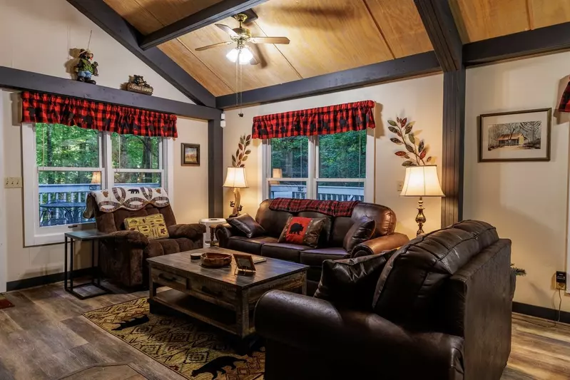Misty Mountain Hop – a 2-bedroom, 2-bath Smoky Mountain cabin in Cobbly Nob Resort with screened-in hot tub, wrap-around decks, wood-burning fireplace, and access to pools, pickleball, and golf.