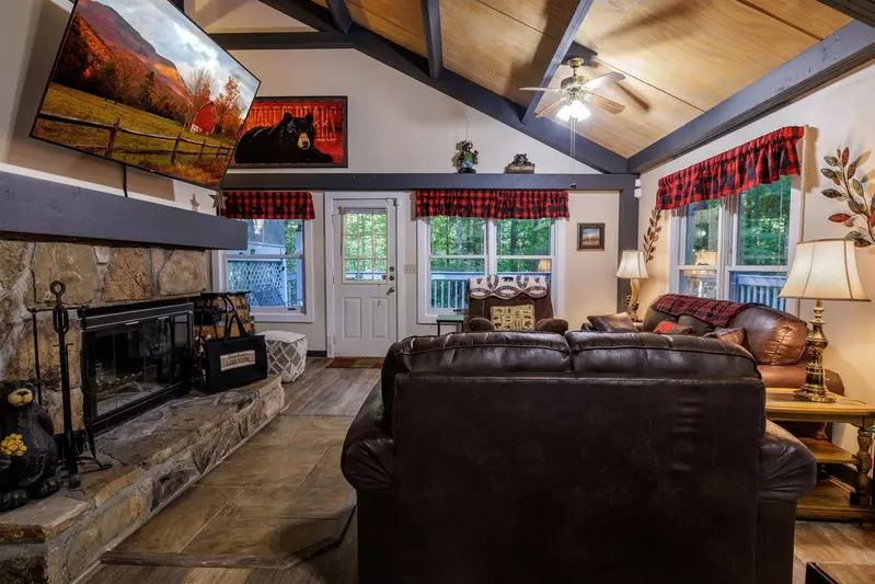Misty Mountain Hop – a 2-bedroom, 2-bath Smoky Mountain cabin in Cobbly Nob Resort with screened-in hot tub, wrap-around decks, wood-burning fireplace, and access to pools, pickleball, and golf.