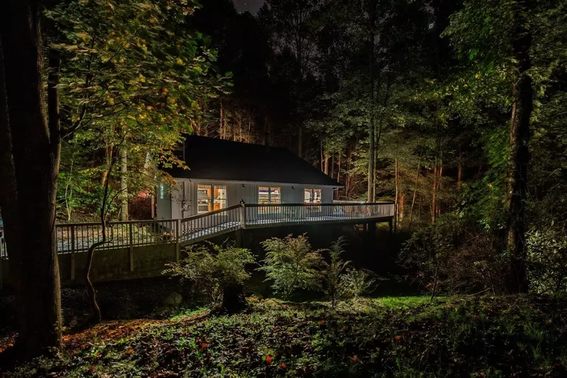Misty Mountain Hop – a 2-bedroom, 2-bath Smoky Mountain cabin in Cobbly Nob Resort with screened-in hot tub, wrap-around decks, wood-burning fireplace, and access to pools, pickleball, and golf.