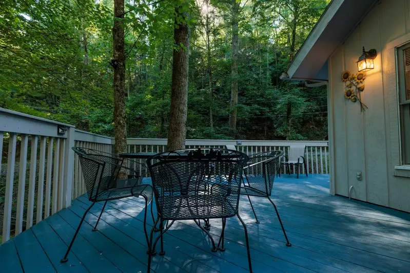 Misty Mountain Hop – a 2-bedroom, 2-bath Smoky Mountain cabin in Cobbly Nob Resort with screened-in hot tub, wrap-around decks, wood-burning fireplace, and access to pools, pickleball, and golf.