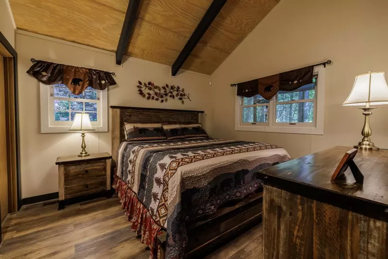 Misty Mountain Hop – a 2-bedroom, 2-bath Smoky Mountain cabin in Cobbly Nob Resort with screened-in hot tub, wrap-around decks, wood-burning fireplace, and access to pools, pickleball, and golf.