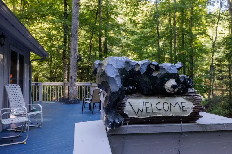 Misty Mountain Hop – a 2-bedroom, 2-bath Smoky Mountain cabin in Cobbly Nob Resort with screened-in hot tub, wrap-around decks, wood-burning fireplace, and access to pools, pickleball, and golf.