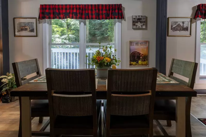 Misty Mountain Hop – a 2-bedroom, 2-bath Smoky Mountain cabin in Cobbly Nob Resort with screened-in hot tub, wrap-around decks, wood-burning fireplace, and access to pools, pickleball, and golf.