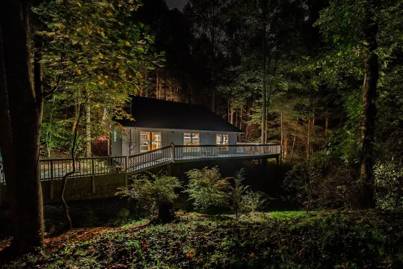 Misty Mountain Hop – a 2-bedroom, 2-bath Smoky Mountain cabin in Cobbly Nob Resort with screened-in hot tub, wrap-around decks, wood-burning fireplace, and access to pools, pickleball, and golf.