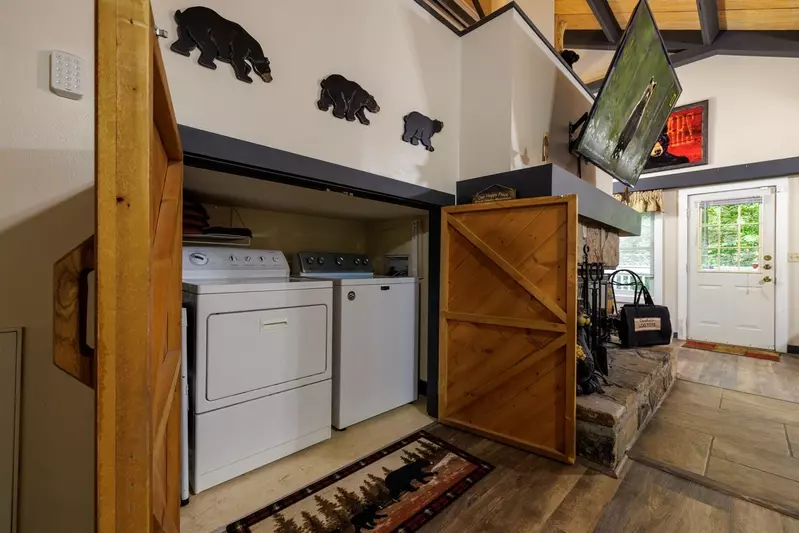 Misty Mountain Hop – a 2-bedroom, 2-bath Smoky Mountain cabin in Cobbly Nob Resort with screened-in hot tub, wrap-around decks, wood-burning fireplace, and access to pools, pickleball, and golf.