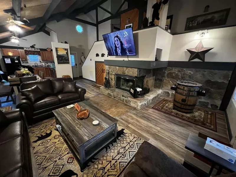 Misty Mountain Hop – a 2-bedroom, 2-bath Smoky Mountain cabin in Cobbly Nob Resort with screened-in hot tub, wrap-around decks, wood-burning fireplace, and access to pools, pickleball, and golf.