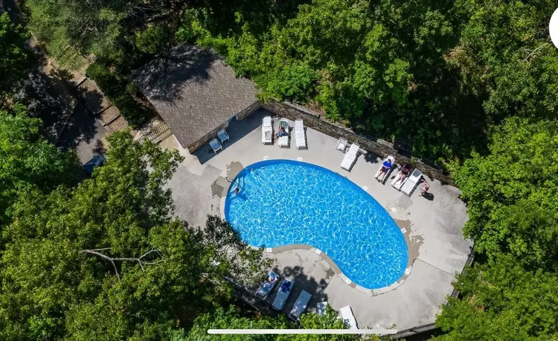 Misty Mountain Hop – a 2-bedroom, 2-bath Smoky Mountain cabin in Cobbly Nob Resort with screened-in hot tub, wrap-around decks, wood-burning fireplace, and access to pools, pickleball, and golf.