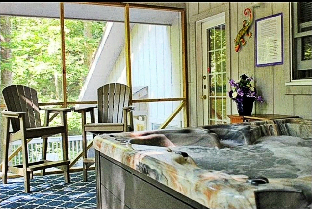 Misty Mountain Hop – a 2-bedroom, 2-bath Smoky Mountain cabin in Cobbly Nob Resort with screened-in hot tub, wrap-around decks, wood-burning fireplace, and access to pools, pickleball, and golf.