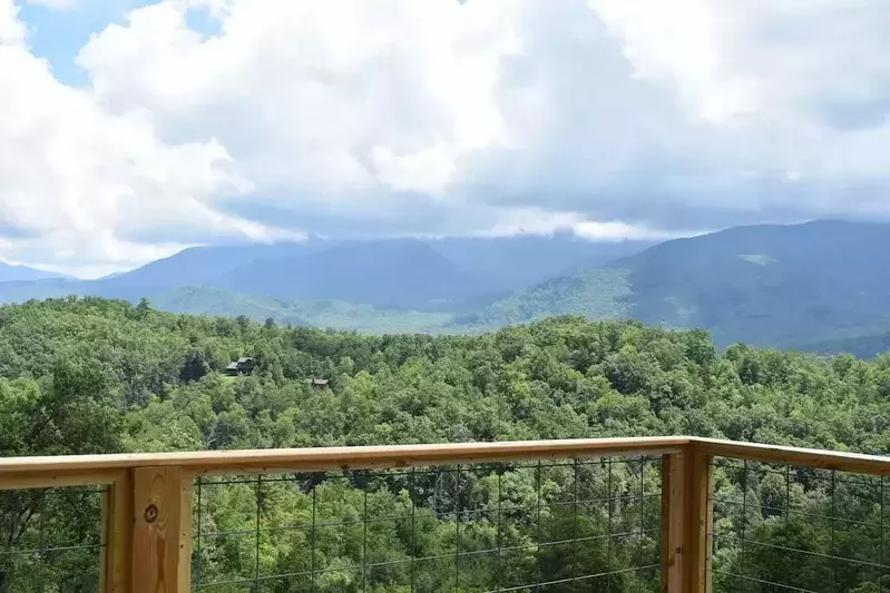 Happy Trails, a spacious 3BR/3BA mountain cabin in Gatlinburg’s coveted Cobbly Nob Resort. Perched on Webb Mountain, this beautifully decorated retreat offers over 2,100 sq. ft. of comfort with panoramic views of three mountain ranges, two wood-burning fireplaces, and plenty of amenities for families and groups to relax and reconnect.