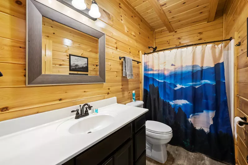 Nothin’ But a Good Time – a spacious 4-bedroom Smoky Mountain cabin rental in Sevierville featuring king bedrooms, twin bunks, hot tub, theater room, fire pit, and cozy mountain views.
