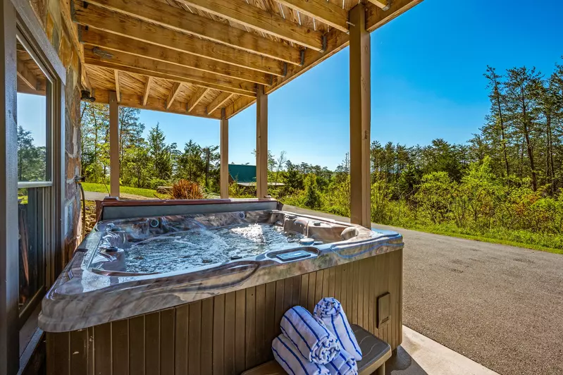 Nothin’ But a Good Time – a spacious 4-bedroom Smoky Mountain cabin rental in Sevierville featuring king bedrooms, twin bunks, hot tub, theater room, fire pit, and cozy mountain views.