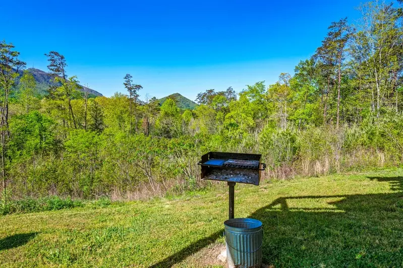 Nothin’ But a Good Time – a spacious 4-bedroom Smoky Mountain cabin rental in Sevierville featuring king bedrooms, twin bunks, hot tub, theater room, fire pit, and cozy mountain views.