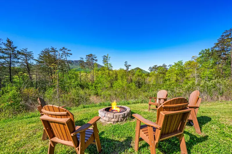 Nothin’ But a Good Time – a spacious 4-bedroom Smoky Mountain cabin rental in Sevierville featuring king bedrooms, twin bunks, hot tub, theater room, fire pit, and cozy mountain views.