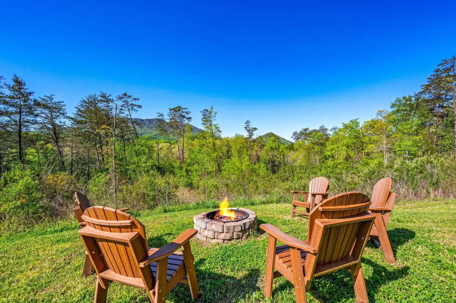 Nothin’ But a Good Time – a spacious 4-bedroom Smoky Mountain cabin rental in Sevierville featuring king bedrooms, twin bunks, hot tub, theater room, fire pit, and cozy mountain views.