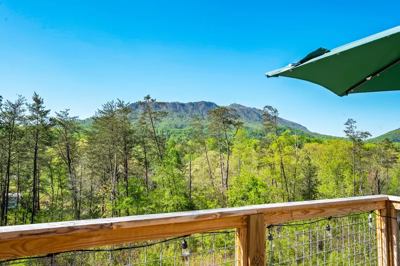 Nothin’ But a Good Time – a spacious 4-bedroom Smoky Mountain cabin rental in Sevierville featuring king bedrooms, twin bunks, hot tub, theater room, fire pit, and cozy mountain views.